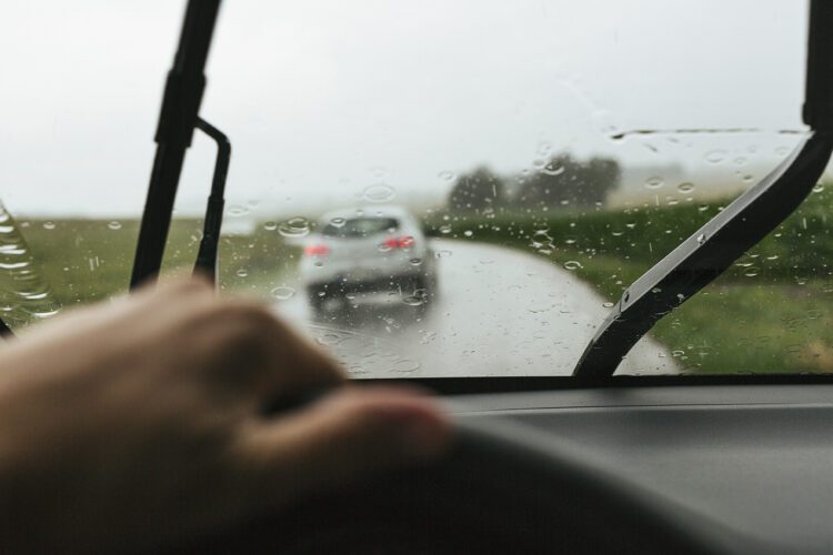 Interior view of man driving car in rain